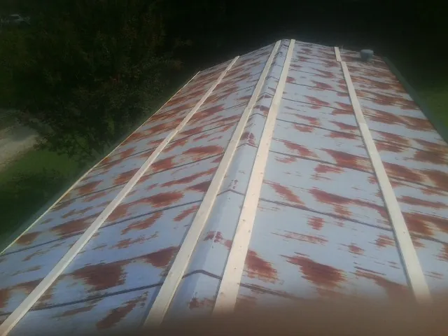 Rusted metal roof panels with new wood purlins before replacement — Storm Damage Roof Repair in Bon Secour by Roofing Brothers