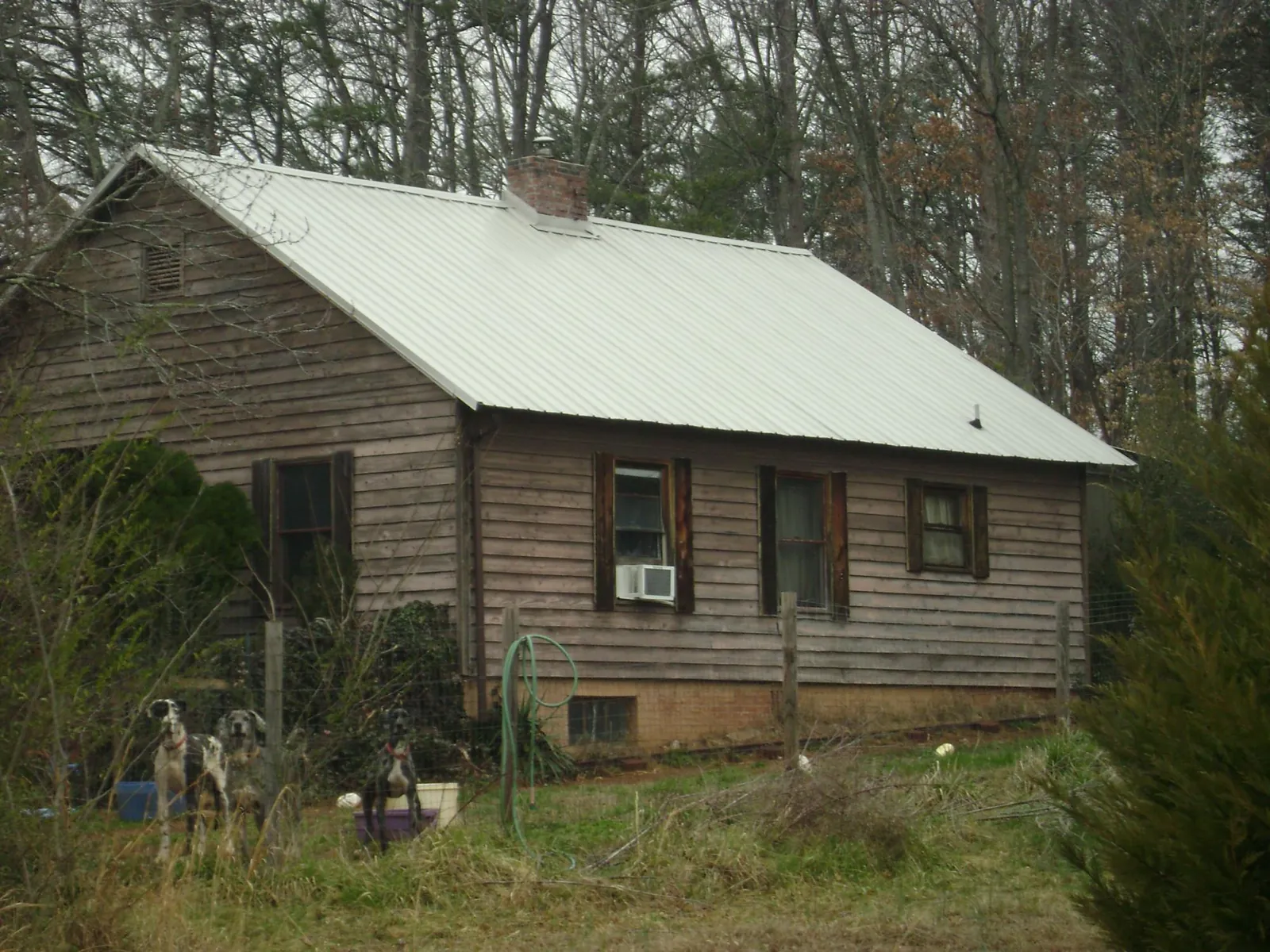White metal roof on an old wood sided farmhouse, from a Metal Roof Installation job in Bon Secour